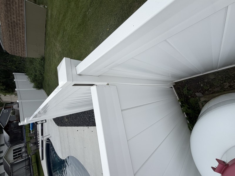 A corner post of the pool enclosure with the rail joint separated and a gap at the base.